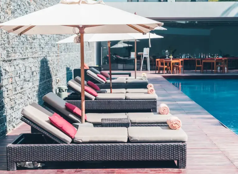 Weather proof outdoor Furniture pool loungers with umbrellas, rattan-style frames and UV-resistant cushions | Urbanland Products